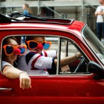 Turin, Italy - September 24, 2017 - Funny looking couple driving an old red Fiat 500 during a classic car rally in Turin (Italy) on september 24, 2017