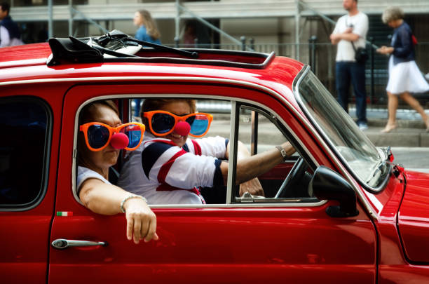 Turin, Italy - September 24, 2017 - Funny looking couple driving an old red Fiat 500 during a classic car rally in Turin (Italy) on september 24, 2017